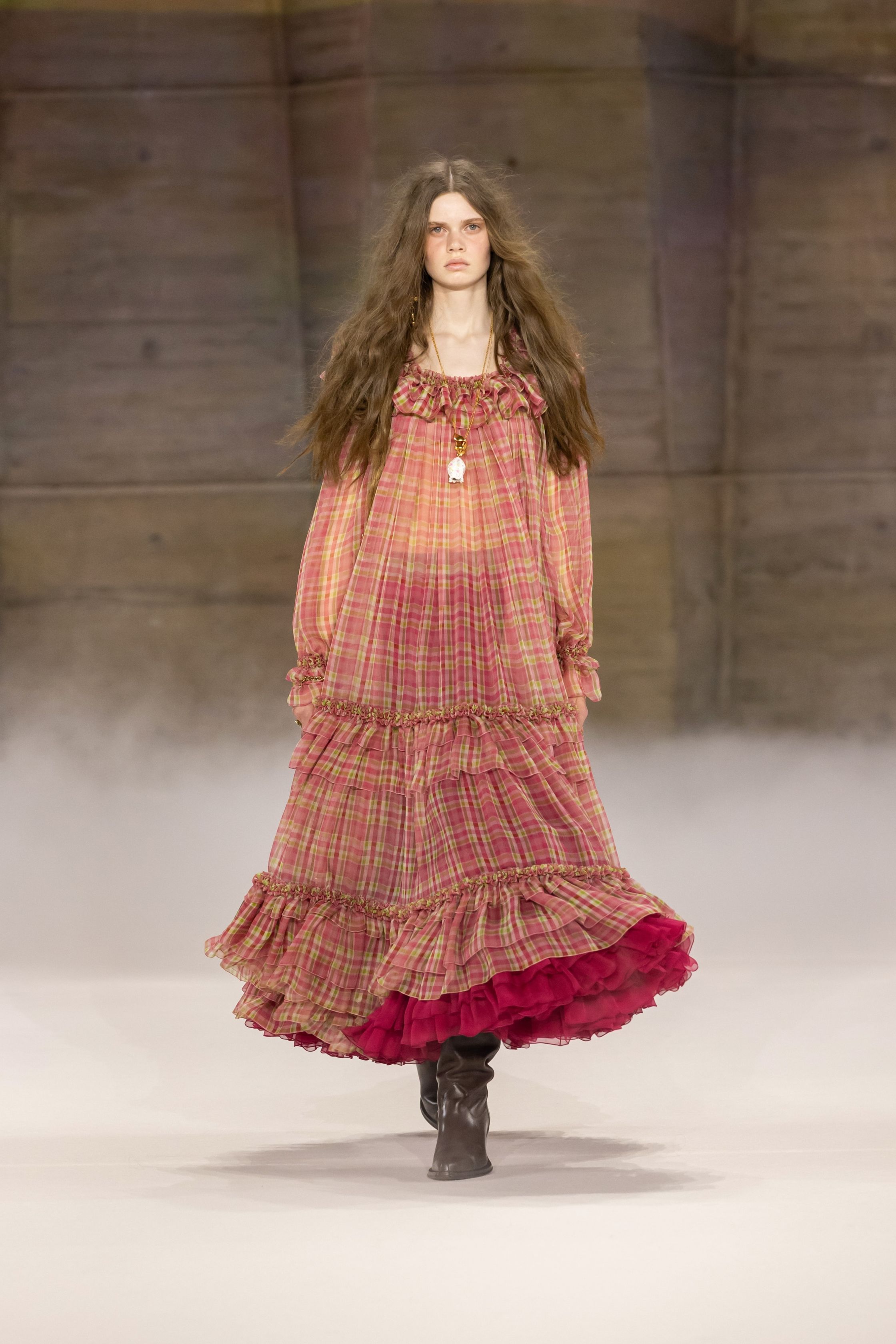 Chloé在2026秋冬继续书写品牌标志性的波西米亚浪漫，通过流动长裙、皮革长靴与柔软披风构建自由而诗意的女性形象。系列色调以大地色、酒红与米色为主，搭配轻盈薄纱与羊毛外套，使整体造型既温暖又富有层次。民族图案、长流苏与复古轮廓让整个系列充满旅行与冒险气息，呈现出典型的Chloé式自由精神-顽石频道趋势研究